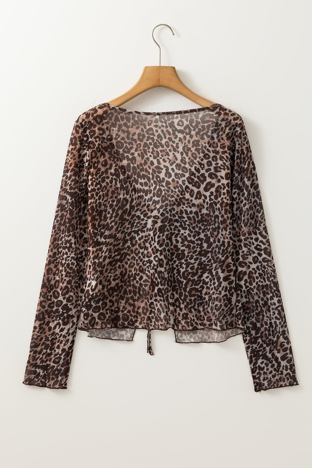 Leopard print top on a wooden hanger against a white background