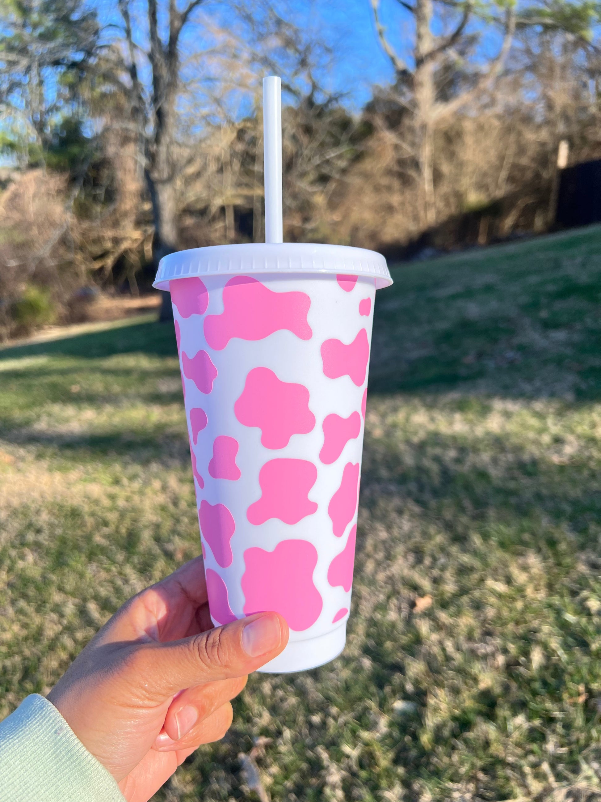 Daisie Boutique cow print cold cup 24 ounce side view showing animal print vinyl design with straw Nashville